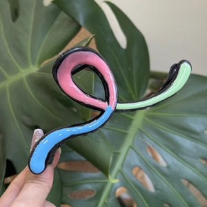 Detail of colorful wave claw clip with pink, mint green and blue glossy finish textures