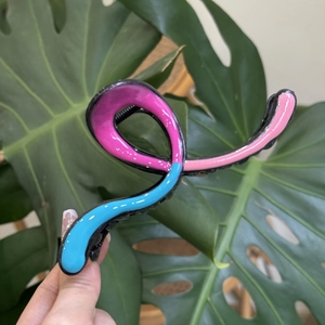 Macro detail of large colorful resin hair claw clip with blue and pink wave pattern