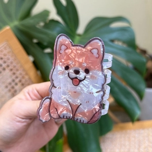 Dettaglio del mollettone Shiba Inu in acetato con finitura perlata e design di un cucciolo