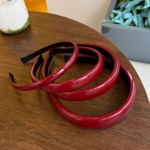 Detailed set of four glossy red PU leather headbands with shiny reflective finish
