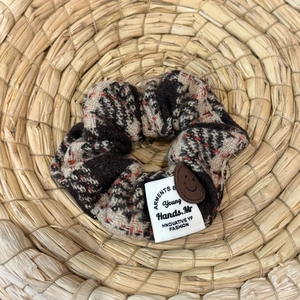 Detail of a brown houndチェック pattern hair scrunchie with smiley patch on straw tray