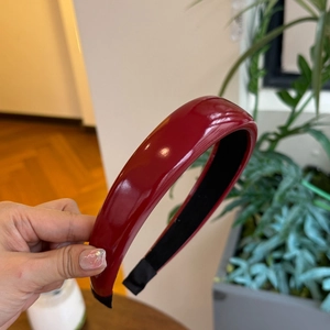Detail view of glossy red PU leather headband with black non-slip lining and high shine