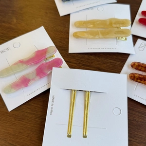 Détail de barrettes à cheveux en acétate ondulées roses, jaunes et écaille de tortue