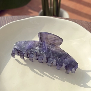 Detailed view of square purple marble acetate hair claw clip with strong teeth