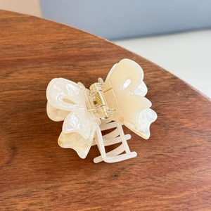 Elegant acetate butterfly hair claw clip with marble texture and golden spring mechanism