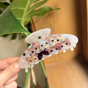 Macro view of pearlescent acrylic hair claw featuring cute colorful cat patterns