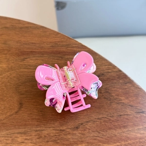 Detail view of pink acetic acid butterfly claw clip with floral purple inner layer