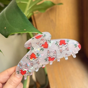 Iridescent acrylic hair claw clip with cute cat and heart patterns on wood background