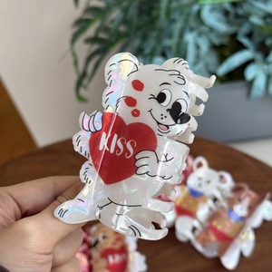 Detailed close-up of pearlescent acrylic bear hair claw clip with red KISS heart