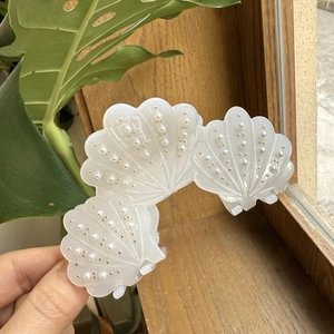 Pince à cheveux élégante en acétate blanc avec accents de perles et décors de perles dorées