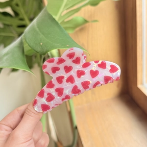 Close-up of iridescent heart hair claw clip with pearlescent finish and wavy edges