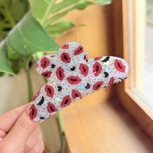 Close-up of heart and red lip patterned acrylic hair claw clip with holographic finish