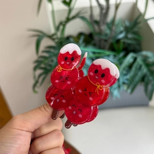 Detail of red acrylic hair claws shaped like traditional Chinese candied haws with cute faces