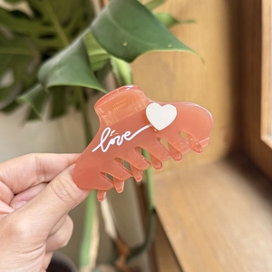 Close-up of pink acetate cat hair claw clip featuring a 3D heart and white Love lettering
