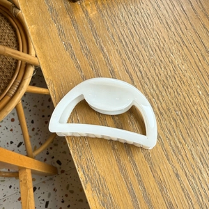 Elegant ivory hollow semicircular hair claw clip on wooden desk for women styling