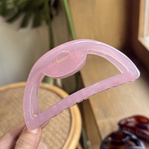 Pink translucent half-round hair claw clip made of resin with butterfly spring design