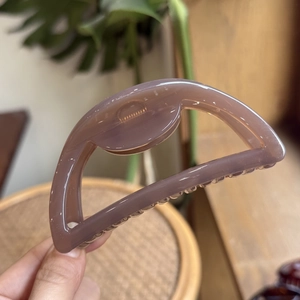 Detailed view of large mauve semi-circle hair claw clip with smooth glossy finish