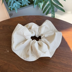 Beige checkered canvas scrunchie with large ruffles on a rustic wooden table background