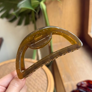 Detail of amber translucent resin hair claw clip with sturdy metal spring mechanism
