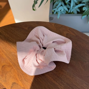Pink checkered scrunchie made of waffle fabric on a wooden background for women