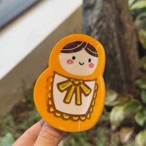 Orange Russian Matryoshka doll hair claw clip made of glossy acrylic for women's hair styling