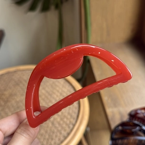 Detailed macro view of 10cm red semi-circle hair claw clip showing polished texture
