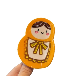 Cute Matryoshka doll hair claw clip in orange acetate with a funny creative cartoon character