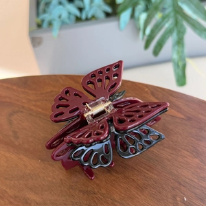 Detail showing the burgundy and black butterfly hair claw with elegant hollow patterns
