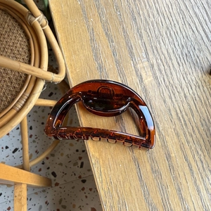 Detailed view of an amber acrylic shark hair clip with a semi-circle hollow design