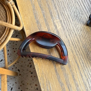 Detail showing the tortoiseshell pattern and hollow semi-circle design of the large hair claw