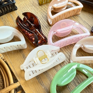 Detailed close-up of semi-circular hollow hair claws in various vibrant pastel colors