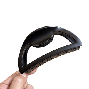Minimalist 10cm black hollow semi-circle hair claw clip for women held in hand