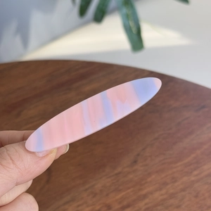 Détail macro de l'élégante texture marbrée colorée sur la pince à cheveux ovale
