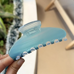Close-up of light blue acetate hair claw clip with a frosted finish and 7 teeth design