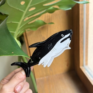 Elegant orca-shaped acetate hair claw clip with a glossy black and white finish
