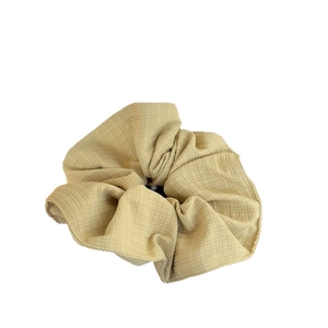Minimalist beige checkered canvas hair scrunchie with soft fabric texture