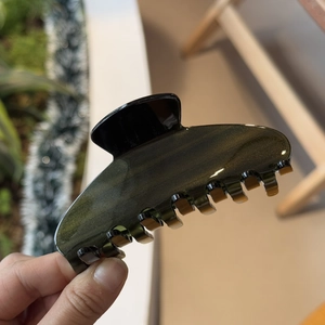 Close-up of a large green glitter acetate hair claw clip with a glossy finish