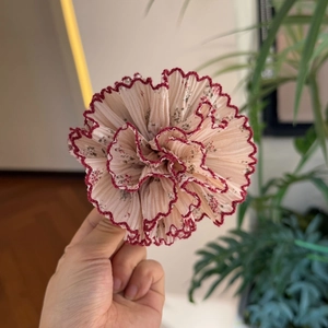 Handheld floral chiffon flower hair clip with tiered petal layers and red trim