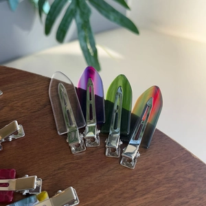 Close-up of translucent colorful acrylic hair clips on a textured wooden background