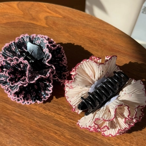 Detail view of French-style floral fabric hair claws on a rustic wooden tabletop