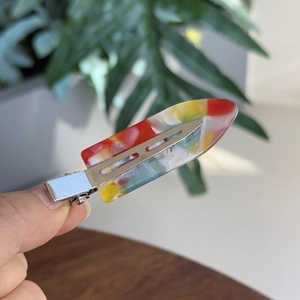 Artistic acetate hair clip with vibrant color blocks and a silver metal duckbill grip