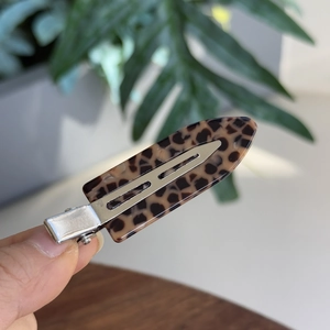 Detail shot of leopard print hair clip with silver metal clip and acetate finish