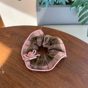 Detail of pink and brown plaid hair scrunchie with button decoration and handmade label