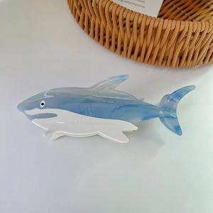 Shark-shaped acetate hair claw clip featuring a blue and white marble pattern design
