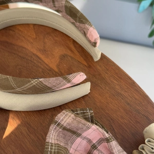 Detailed view of vintage plaid fabric headbands and matching scrunchie on wood surface