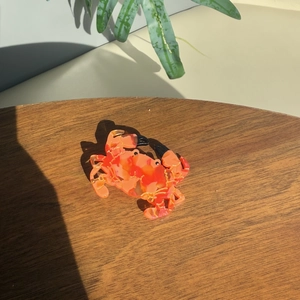 Orange marble acetate crab hair claw clip with gold accents on a wooden background