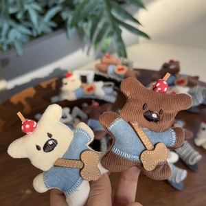 Détail de pinces à cheveux chiot en peluche avec pulls rayés et motifs champignons
