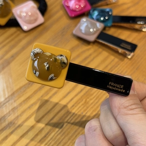 Detailed close-up of a handmade bear hair clip showing the France Handmade gold stamp