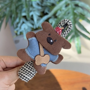 Gros plan d'une pince à cheveux petit chien en velours côtelé avec base en tissu à carreaux