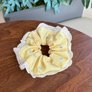 Floral plaid hair scrunchie with lace trim and colorful embroidery on yellow cotton fabric